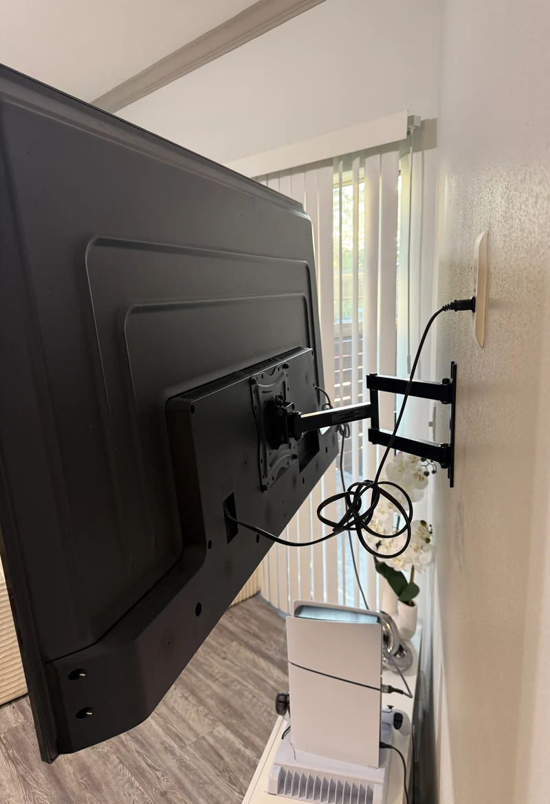 Side view of an installed television with its articulated bracket extended