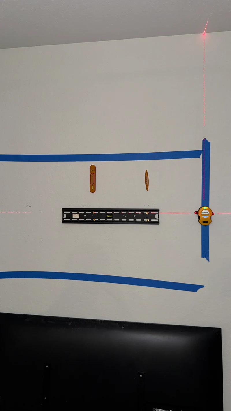 Wall bracket installed within a tape outline with laser alignment reference
