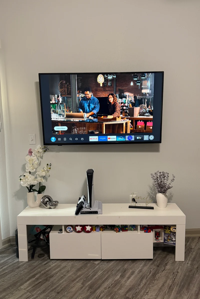 TV mounted above a white media console, with no HDMI cable hanging below the screen